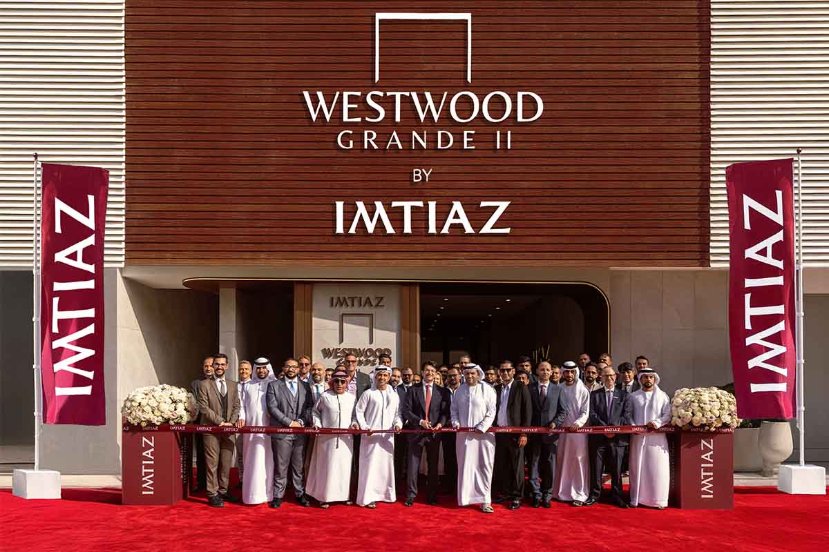 Events?Page=2 A group of people stands in front of the Westwood Grande II building, holding a ribbon for its opening ceremony.